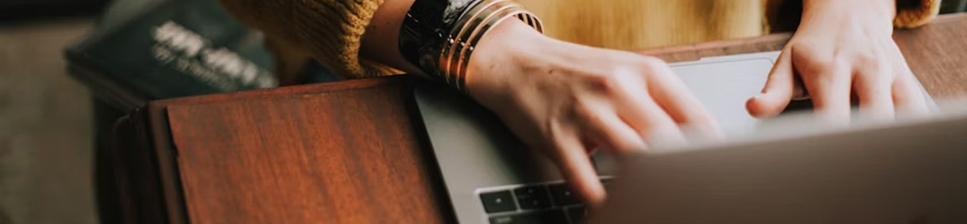 Persona escribiendo en un ordenador como símbolo del trabajo de divulgación científica y difusión del conocimiento en neurología de la Dra. María Dolores Calabria.